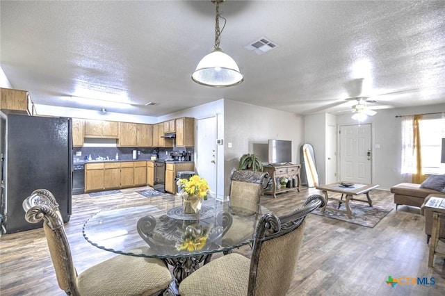 dining space with a textured ceiling, ceiling fan, and hardwood / wood-style flooring