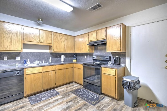 kitchen featuring a textured ceiling, light hardwood / wood-style flooring, black appliances, decorative backsplash, and sink