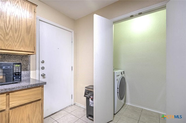 clothes washing area featuring washer / dryer and light tile patterned floors