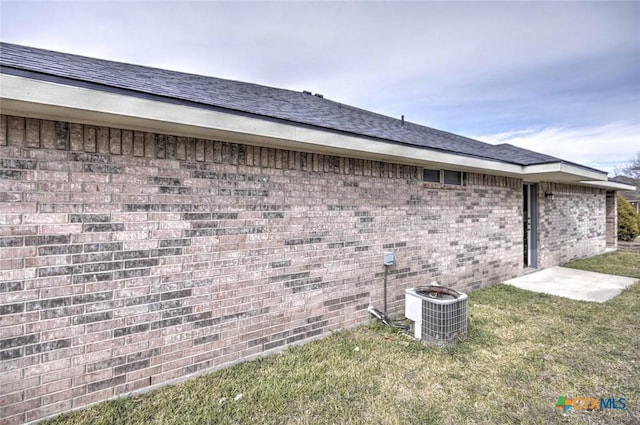 view of home's exterior featuring central air condition unit and a yard