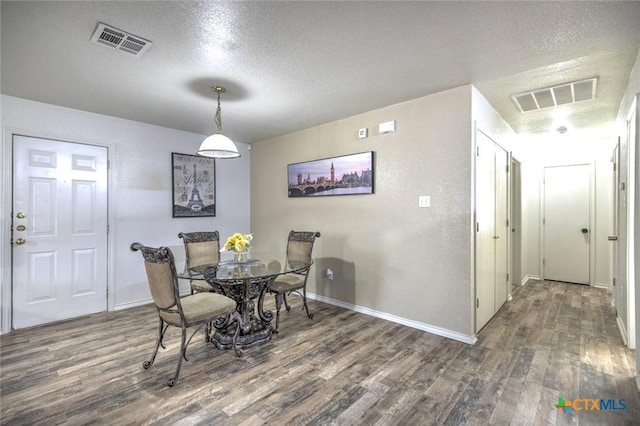 dining room with dark hardwood / wood-style flooring and a textured ceiling