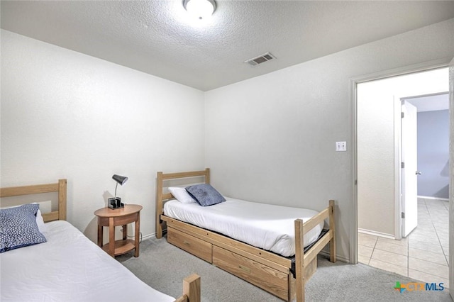 bedroom featuring a textured ceiling and light carpet