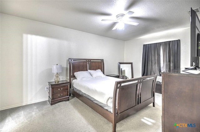 carpeted bedroom with ceiling fan and a textured ceiling