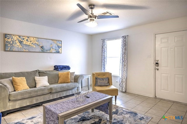 tiled living room with a textured ceiling and ceiling fan