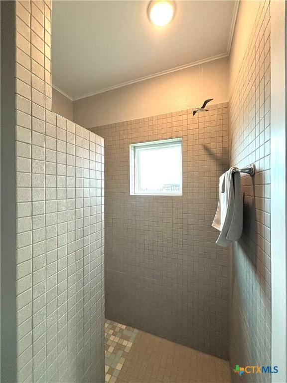 bathroom featuring tile walls, crown molding, and tiled shower