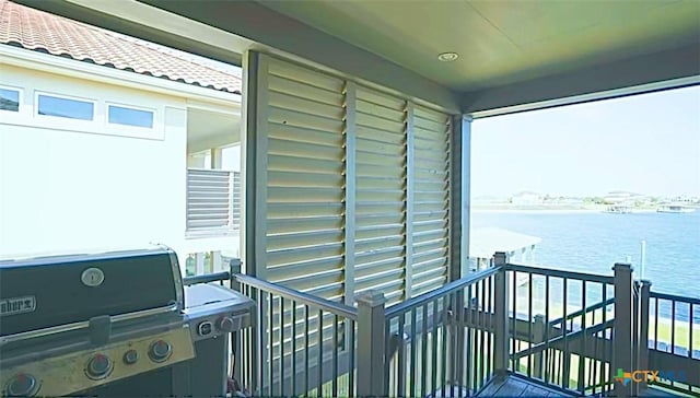 balcony featuring a water view and a grill