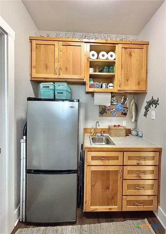 kitchen featuring stainless steel fridge and sink