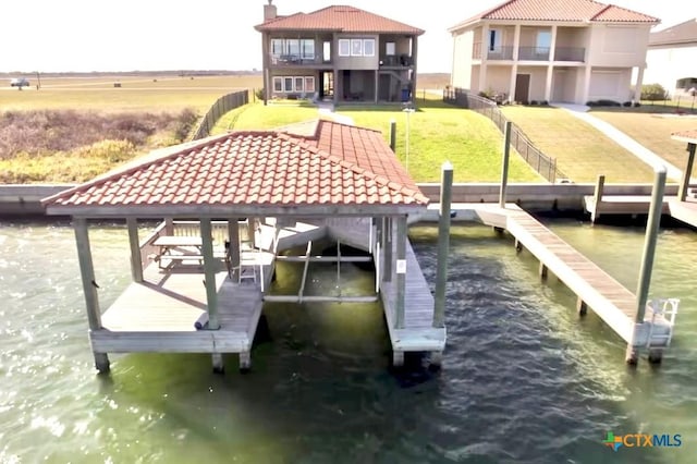 dock area featuring a water view and a lawn