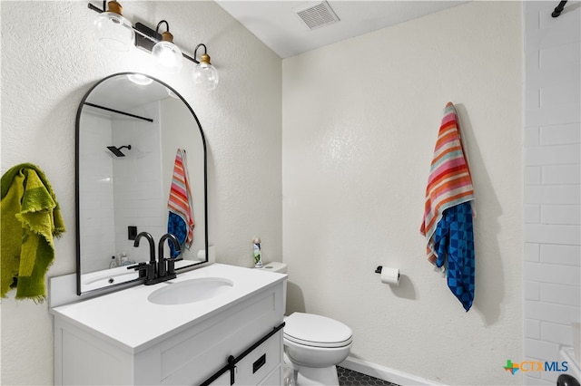 bathroom with a shower, vanity, and toilet