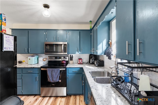 kitchen featuring light hardwood / wood-style floors, sink, stainless steel appliances, and blue cabinets