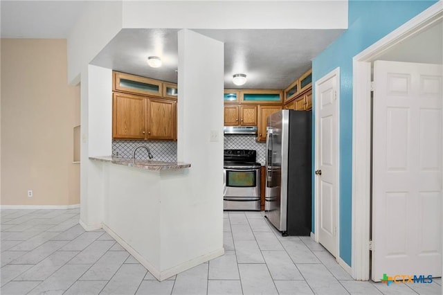 2991 Lakeview E Dr, Ingleside, TX 78362 - kitchen with appliances with stainless steel finishes, under cabinet range hood, backsplash, brown cabinetry, and light countertops