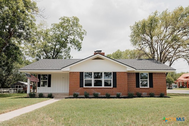 801 E Morgan Ave, Cuero, TX 77954 - view of front of home featuring a front yard, brick siding, a chimney, and roof with shingles