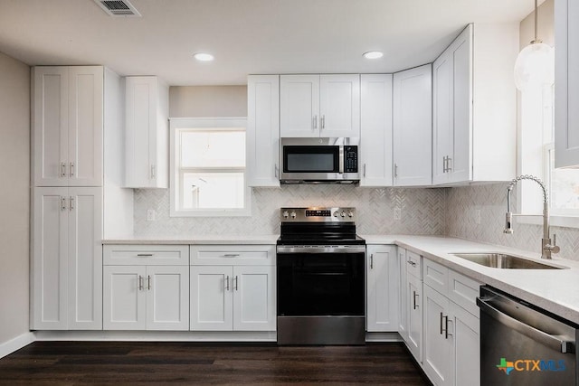 801 E Morgan Ave, Cuero, TX 77954 - kitchen featuring appliances with stainless steel finishes, a sink, white cabinetry, and recessed lighting