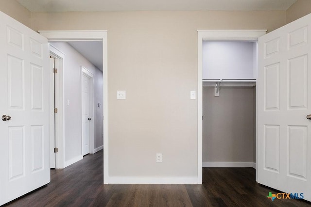 801 E Morgan Ave, Cuero, TX 77954 - unfurnished bedroom with dark wood-type flooring, baseboards, and a closet