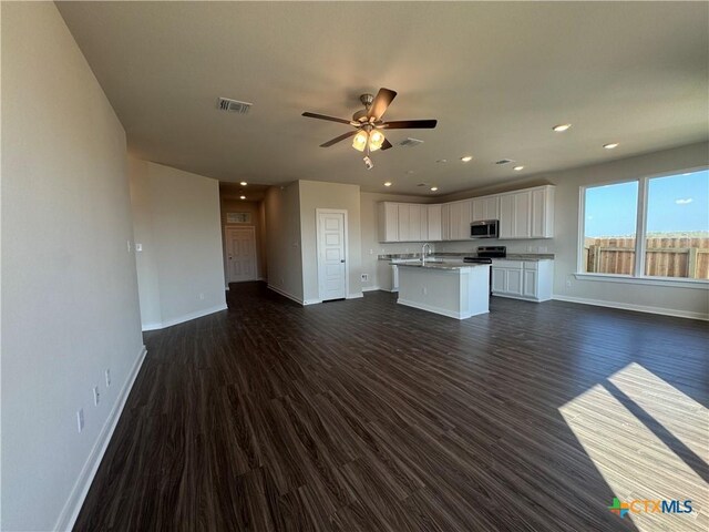 carpeted spare room with visible vents and baseboards