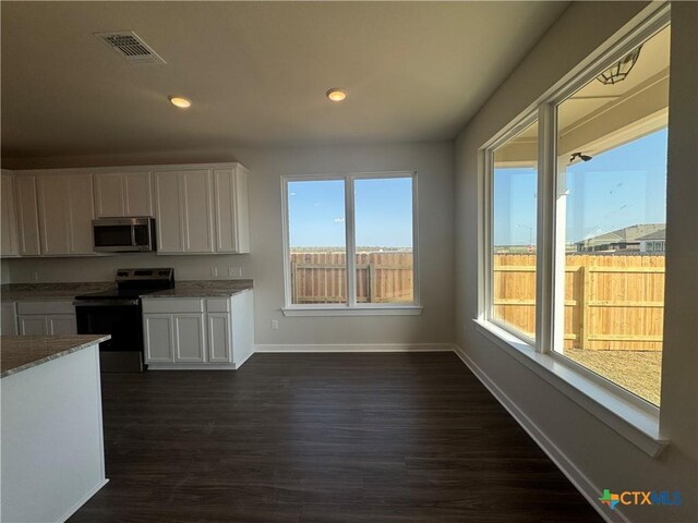 carpeted empty room with visible vents, baseboards, and a ceiling fan