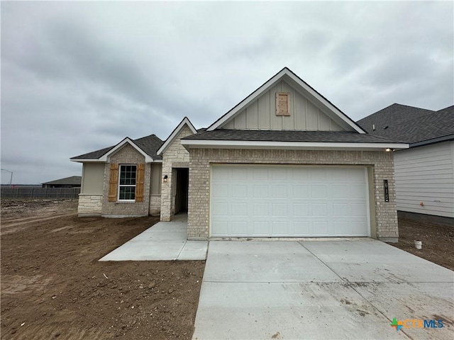 view of front of property with a garage, brick siding, board and batten siding, and concrete driveway