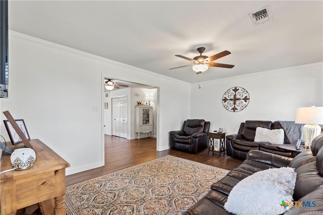 living area with ceiling fan, ornamental molding, wood finished floors, and visible vents