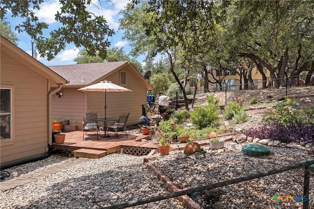 view of yard featuring fence, a deck, and outdoor dining space