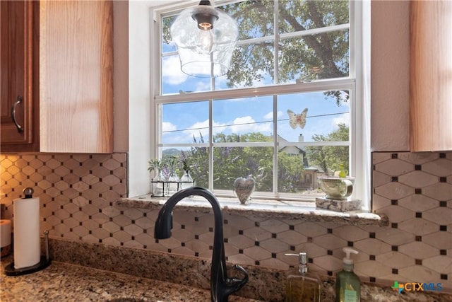 interior details with light stone countertops and decorative backsplash