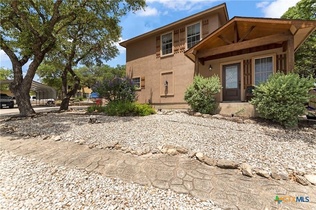 view of front of home featuring a carport and stucco siding