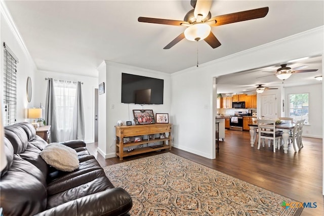 living room featuring ornamental molding, dark wood-style flooring, and a healthy amount of sunlight