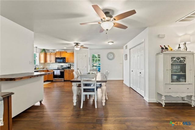 dining area with dark wood-type flooring, plenty of natural light, visible vents, and baseboards