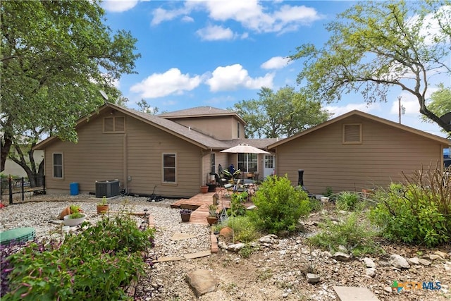 rear view of property with fence and central AC unit