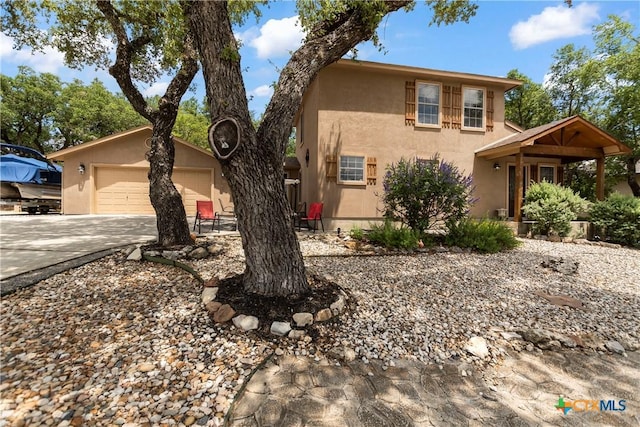 view of front facade featuring a garage, concrete driveway, and stucco siding