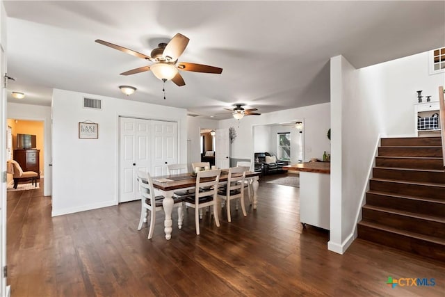 dining area with dark wood-type flooring, stairway, visible vents, and baseboards