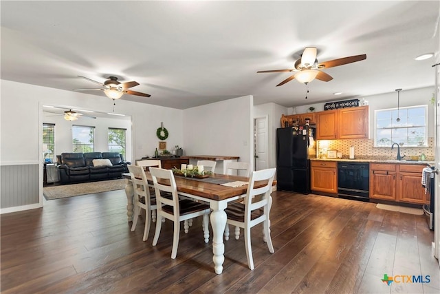 dining area featuring ceiling fan, dark wood-style flooring, and wainscoting