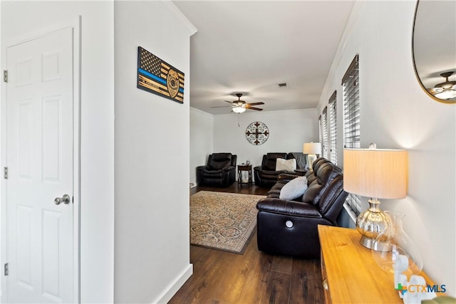 living room featuring ceiling fan, wood finished floors, visible vents, and crown molding