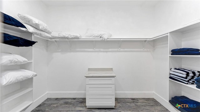 spacious closet with dark wood-style flooring