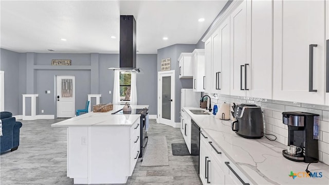 kitchen featuring stainless steel range with electric cooktop, a sink, a center island, island range hood, and backsplash