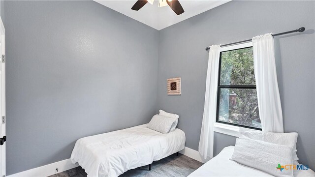 bedroom featuring baseboards, a ceiling fan, and wood finished floors