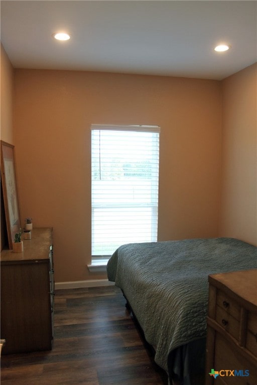 bedroom with dark hardwood / wood-style flooring