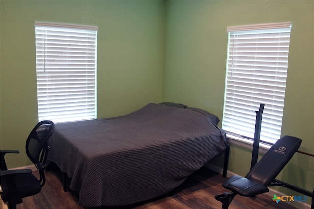 bedroom with dark hardwood / wood-style flooring