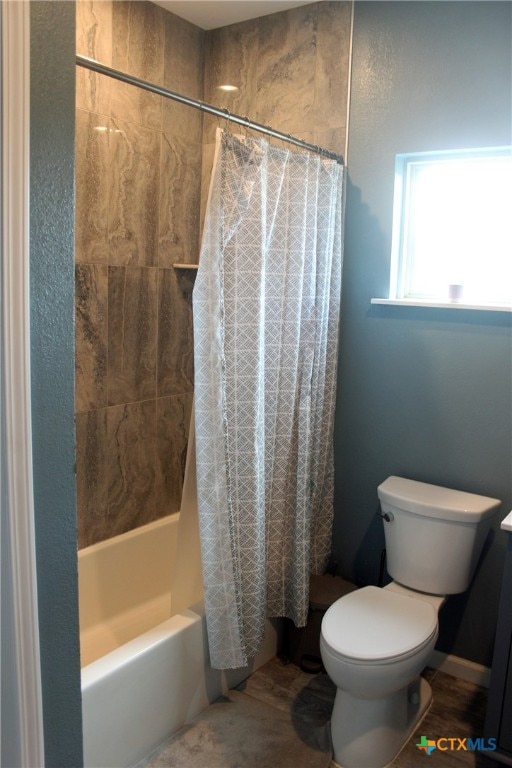 bathroom featuring shower / bath combo with shower curtain and toilet