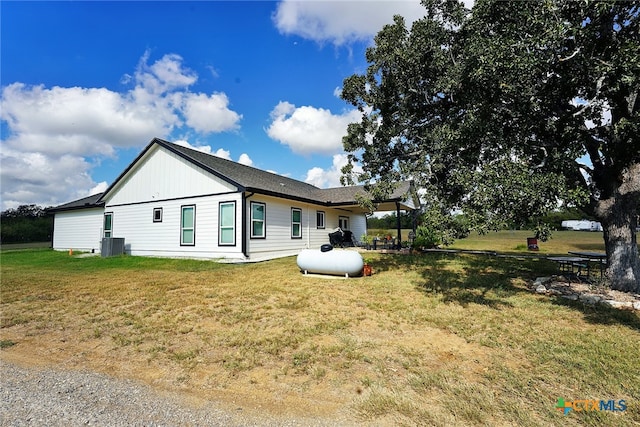 view of home's exterior with central AC unit and a lawn