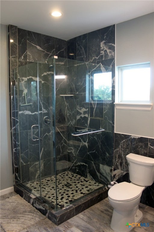 bathroom featuring toilet, an enclosed shower, tile walls, and hardwood / wood-style flooring