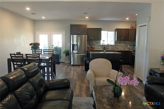 living room featuring dark hardwood / wood-style flooring, sink, french doors, and plenty of natural light