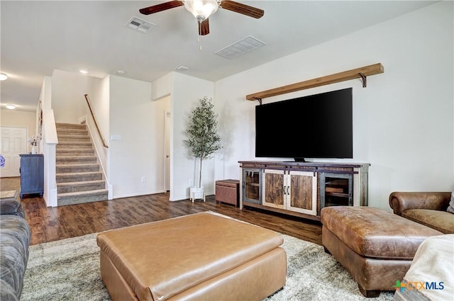 living room featuring dark wood-type flooring and ceiling fan