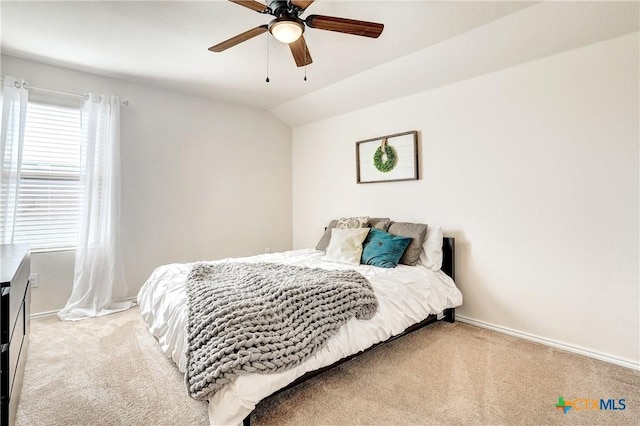 carpeted bedroom with ceiling fan and vaulted ceiling