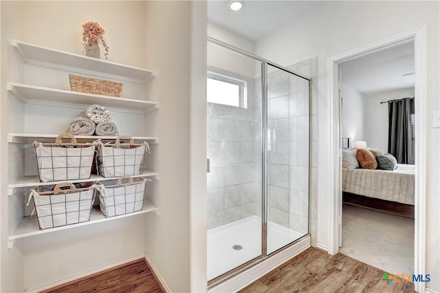 bathroom featuring hardwood / wood-style flooring and a shower with shower door