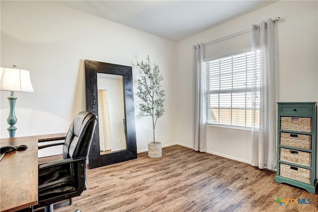 home office with hardwood / wood-style floors and a healthy amount of sunlight