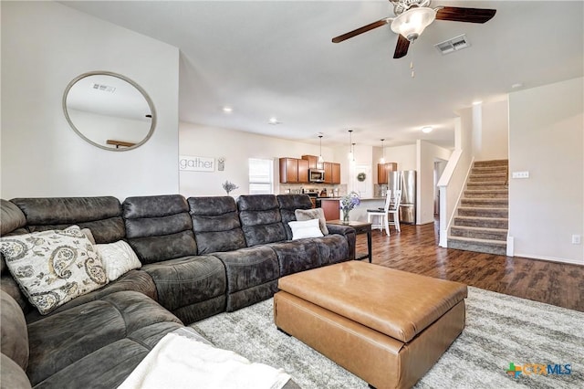 living room featuring ceiling fan and dark hardwood / wood-style flooring