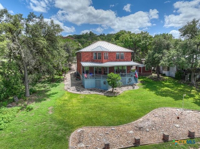 back of property featuring a standing seam roof, a yard, a porch, and metal roof