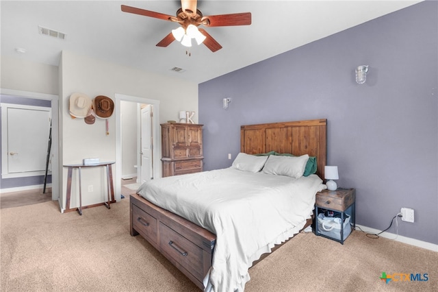 bedroom with baseboards, visible vents, and light colored carpet