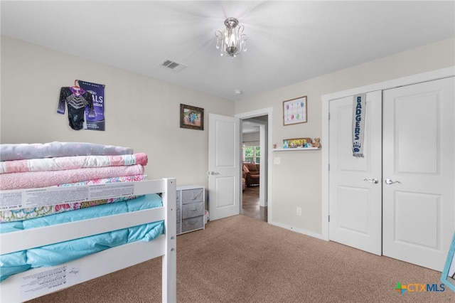 carpeted bedroom featuring a closet, visible vents, and baseboards