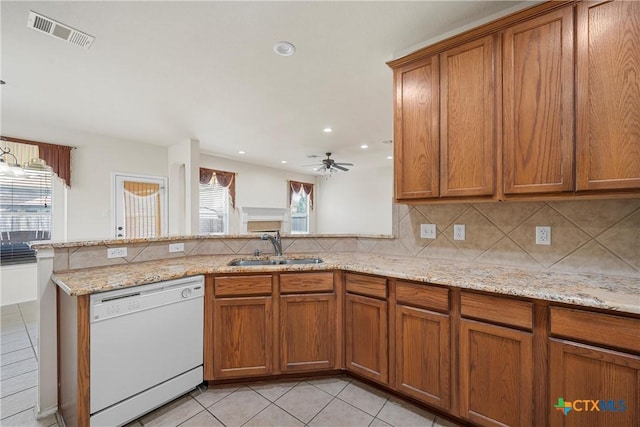 125 Big Timber Dr, Temple, TX 76502 - kitchen with dishwasher, brown cabinetry, a peninsula, light tile patterned floors, and decorative backsplash